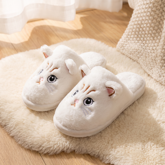 Chaussons Chat câlin blancs sur un tapis en laine